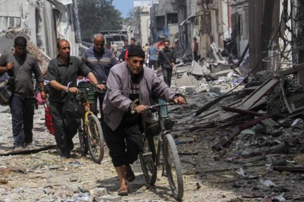 Palestinians walk through rubble in Zeitoun neighbourhood, Gaza City