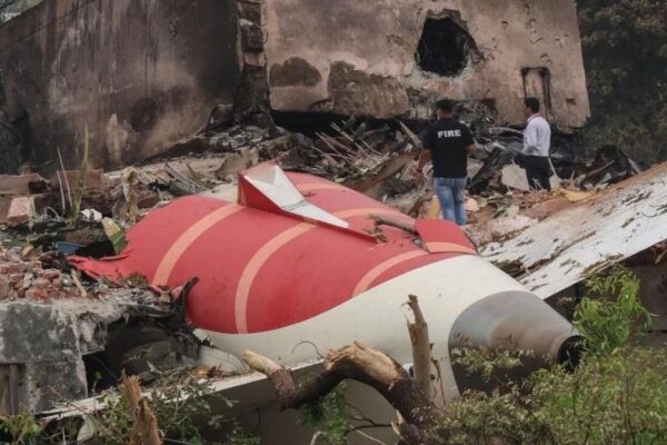 Image shows two officials inspecting the site of an airplane crash near Sardar Vallabhbhai Patel International Airport in Ahmedabad, Gujarat, western India