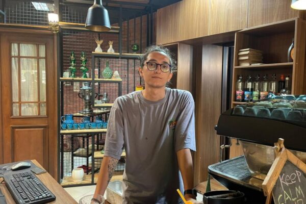 An Iranian man standing behind a counter in a shop