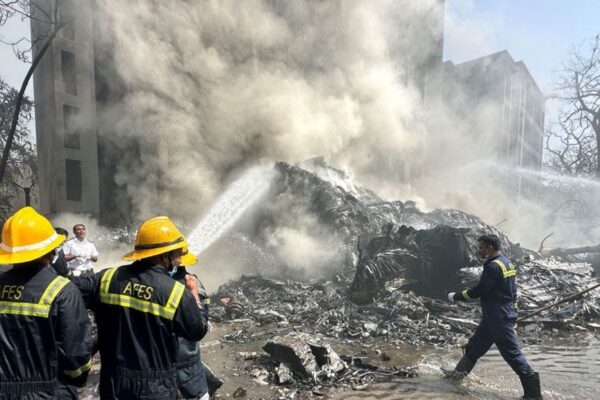 Firefighters tackle plumes of smoke at the scene of the crash