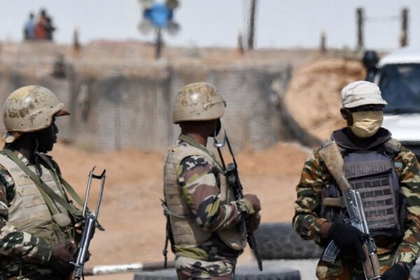 Three unidentified soldiers from Niger wearing camouflages and helmets, holding guns