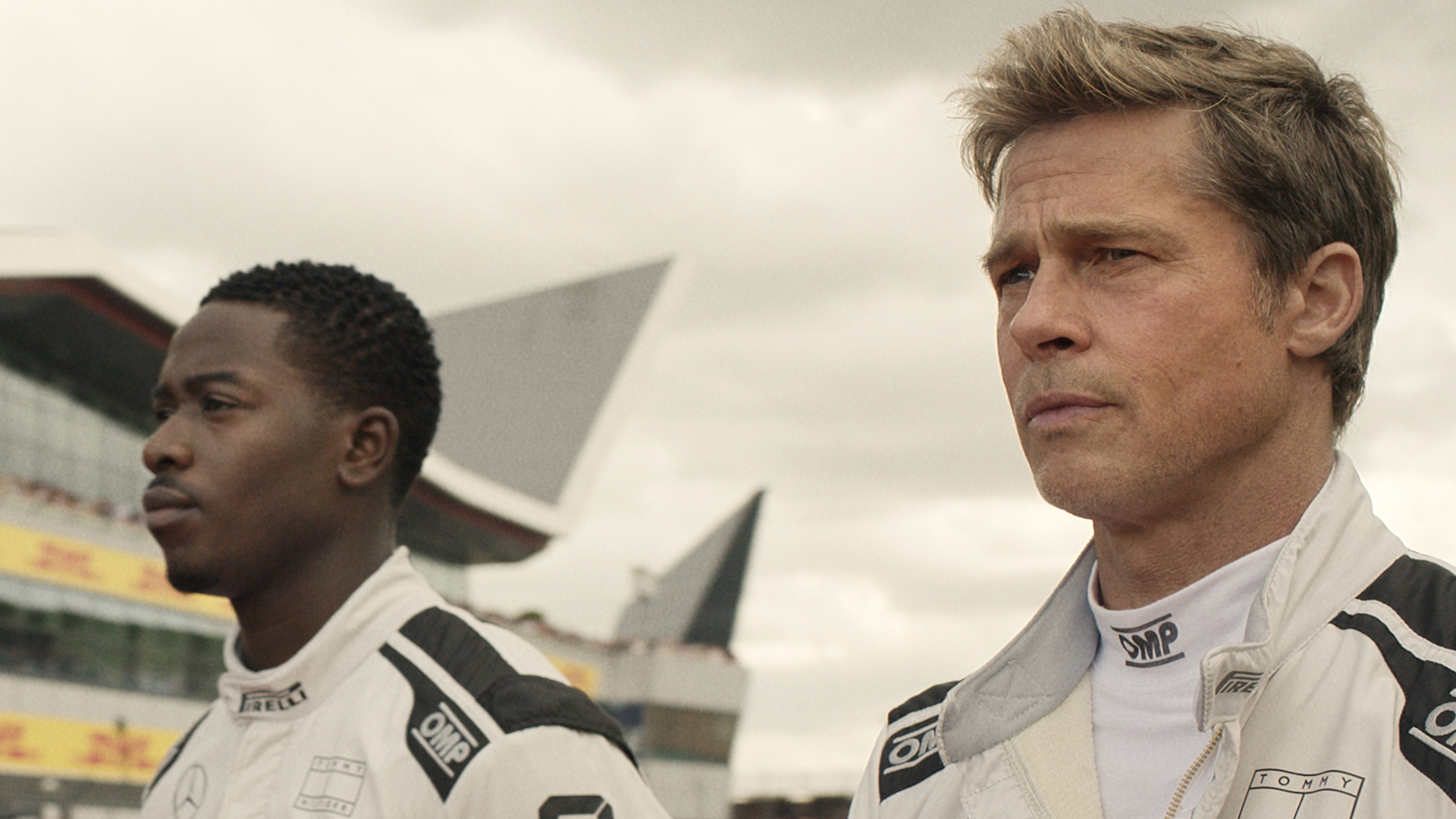 Noah and Sonny standing on a race track in the F1 Movie