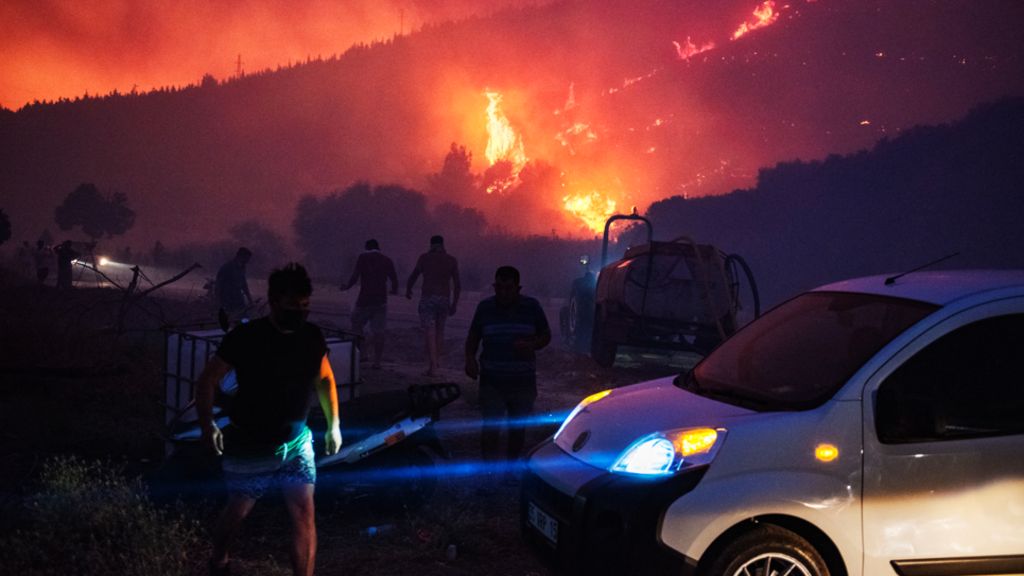 Flames can be seen through smoke on a hillside in the Seferihisar district of Izmir
