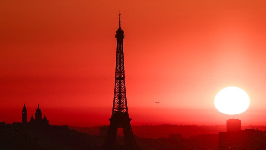 The sun rises by the Eiffel Tower in Paris as the city is on red alert for high temperatures, with the top of the Eiffel Tower shut
